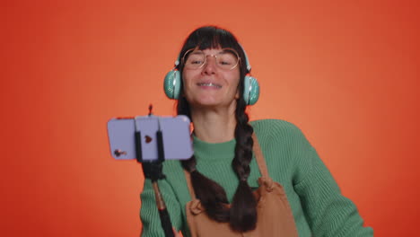 mujer bloguera viajera tomando selfies en el teléfono móvil, bailando videollamada en línea con suscriptores