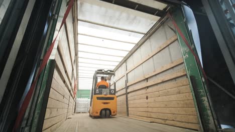 forklift driver transports packaged water bottles in warehouse