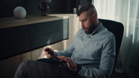professional financial expert working on smartphone and tablet, monitoring real-time stocks, exchange market charts in online trading app. successful businessman in investment bank office. dolly shot.