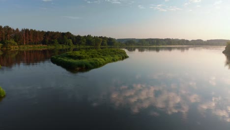 aerial flight over a calm lake at sunset