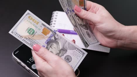 dollars in the hands of a woman, the girl counts banknotes, paper money. family budget, bill payment