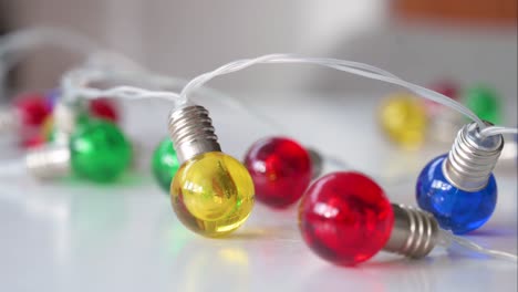 zoomed in of christmas led lights in blue, red, yellow, and green on a white surface