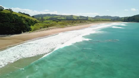 cinematic drone view over surf beach in new zealand's north island