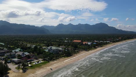 High-altitude-aerial-footage-of-the-beachfront,-coconuts-and-mountains,-fantastic-lovely-sky,-rooftops