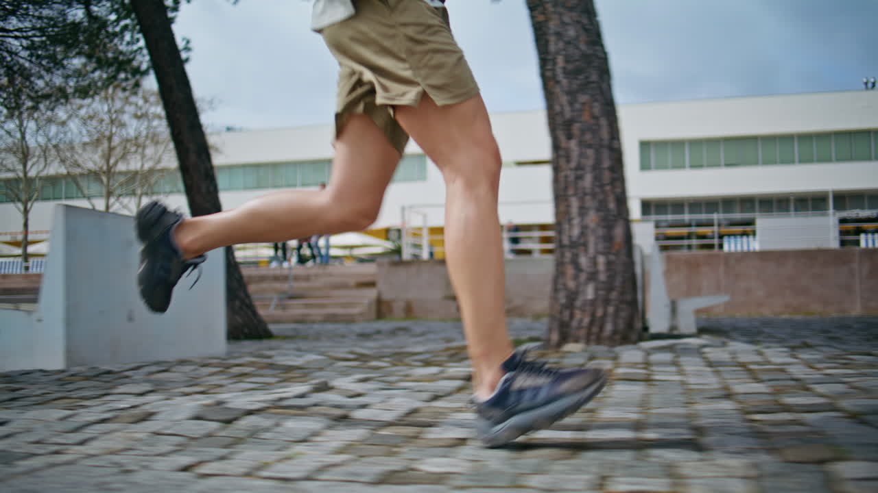 Athletic legs start jogging on sunny street closeup. Motivated sportsman train
