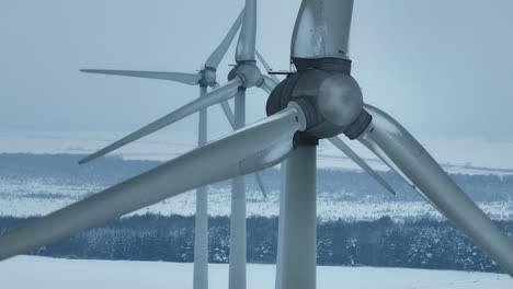 Vista-Aérea-Del-Parque-Eólico-En-Invierno-De-Cerca,-Las-Palas-Giran-Y-Generan-Electricidad-Para-Los-Consumidores