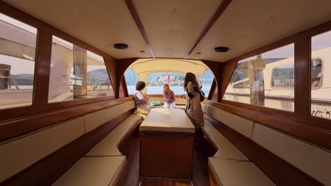 Scenic view inside a cozy wooden boat in Orta San Giulio, Italy, with people seated and enjoying the serene lake ambiance