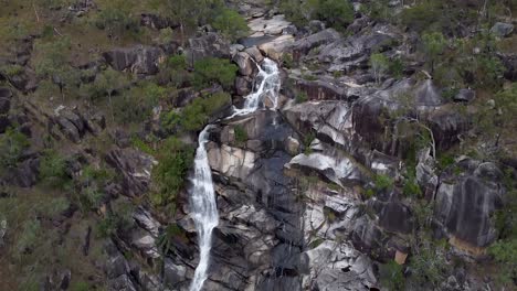 la ladera de la montaña rocosa de davies creek falls en australia - inclinación aérea hacia arriba