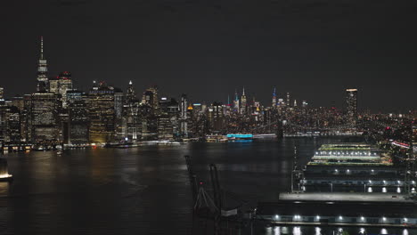 NYC-New-York-Aerial-v282-flyover-waterfront-district-capturing-Manhattan-city-skyline-across-East-river,-panning-reveals-Brooklyn-downtown-cityscape-at-night---Shot-with-Inspire-3-8k---September-2023