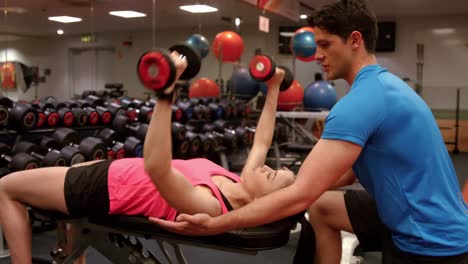 mujer levantando pesas con su entrenador