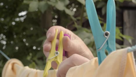 Woman-hanging-clothes-on-the-washing-line-with-pegs