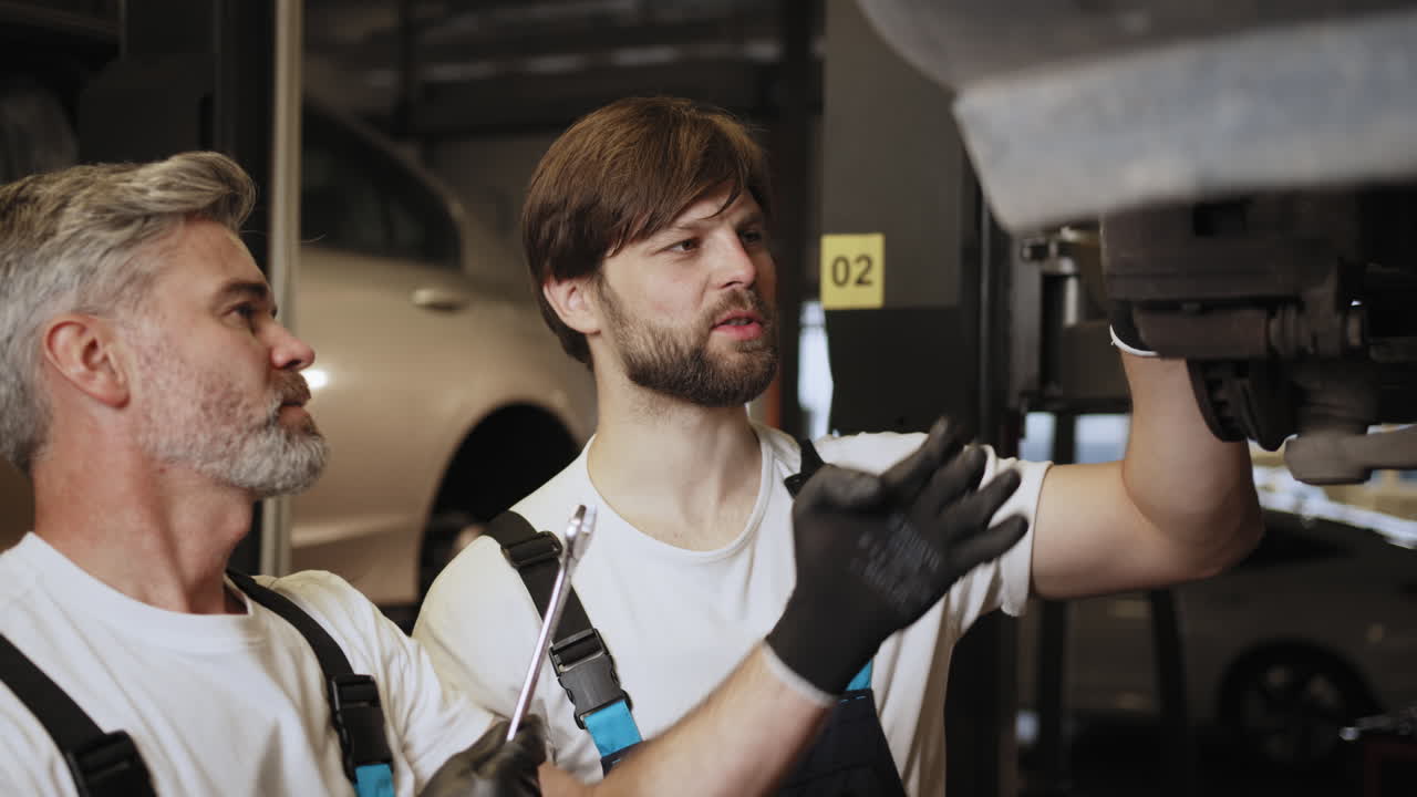 Due meccanici che ispezionano un'auto in un'officina