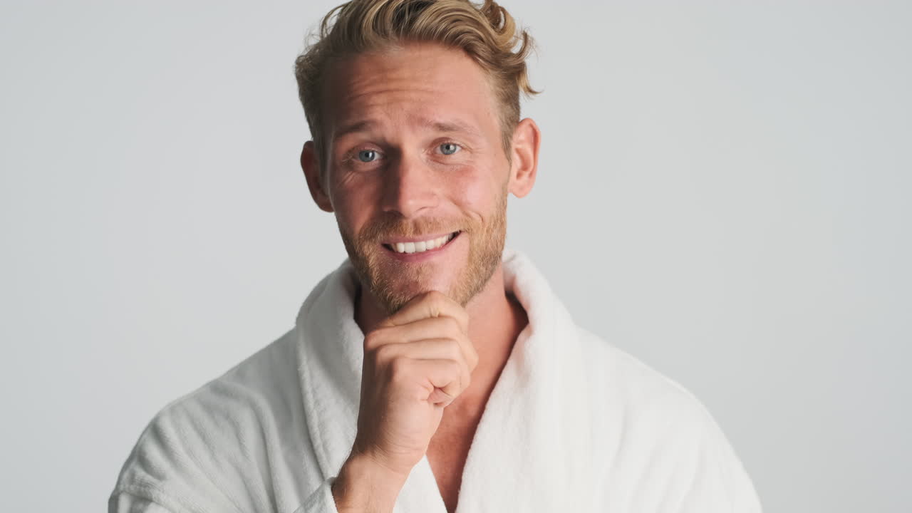 금발 남자가 미소 짓고 포즈를 취하고