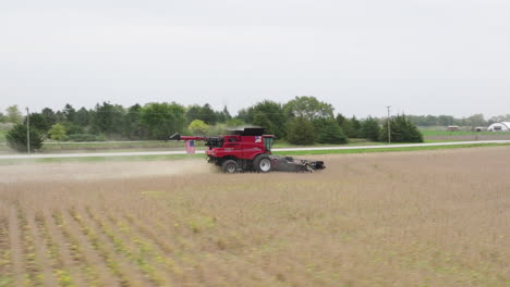 Combine-Harvester-Operating-in-Rural-Soybean-Field-Countryside,-Orbiting-Aerial