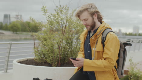 man sitting on bike and using smartphone in city