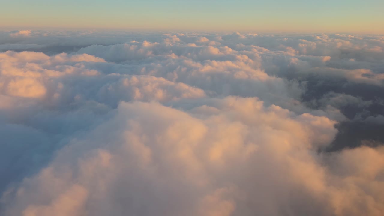 Flying over the clouds illuminated by sunlight