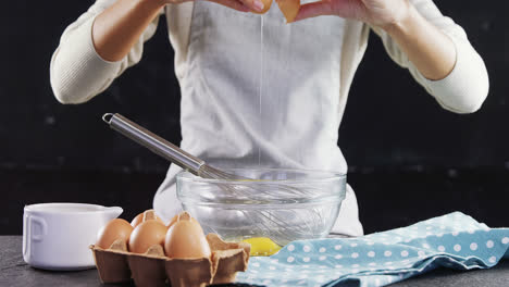 woman breaking eggs into a bowl 4k