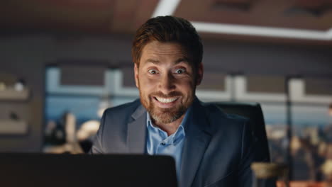 young manager rejoicing profit growth at dark office closeup. happy businessman