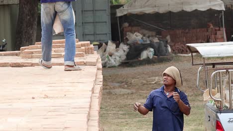 two workers tossing a bag in a coordinated effort