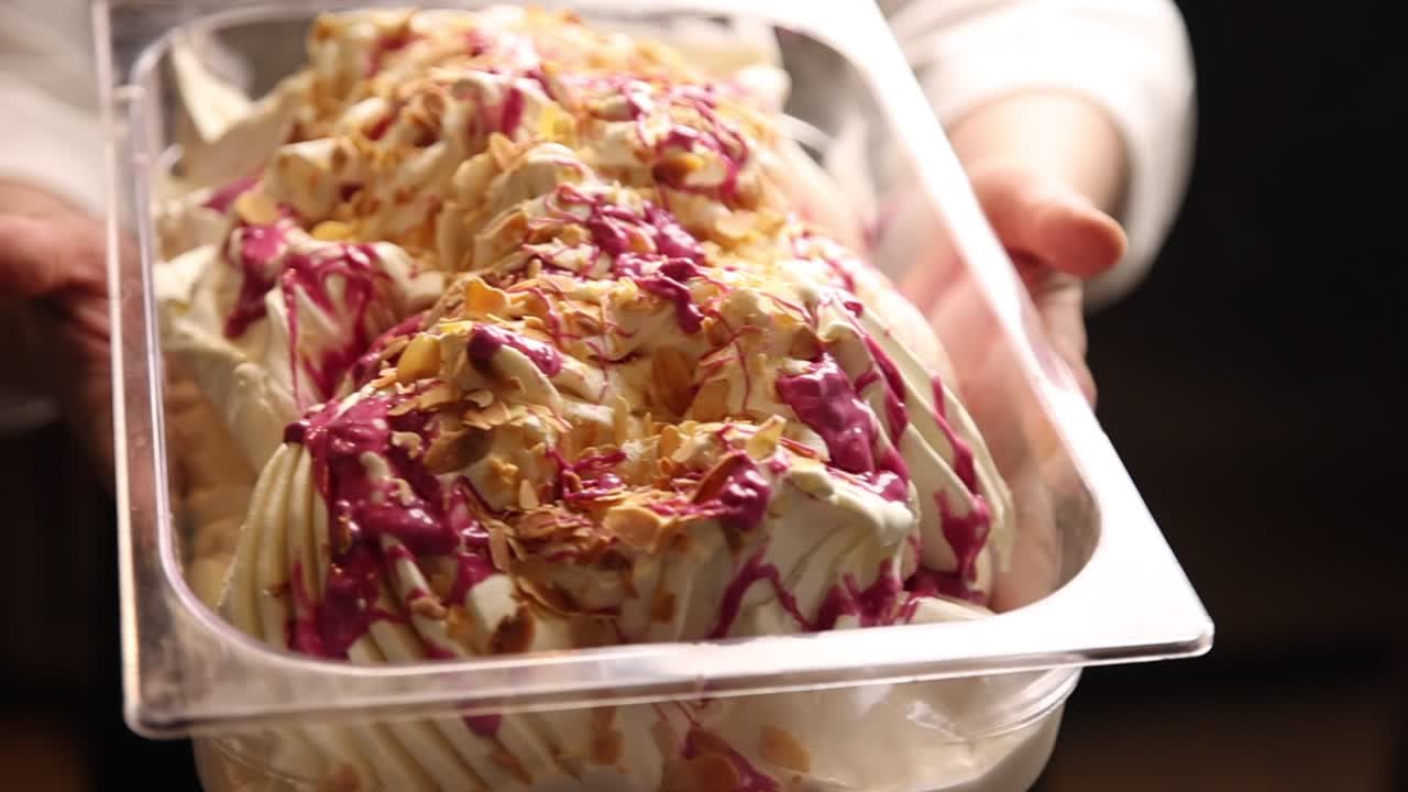 Böğürtlen Soslu ve Bademli Gurme Gelato Kabını Tutan Eller
