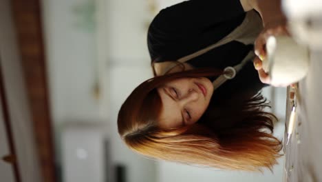 red-haired girl potter forms a ball from a piece of clay