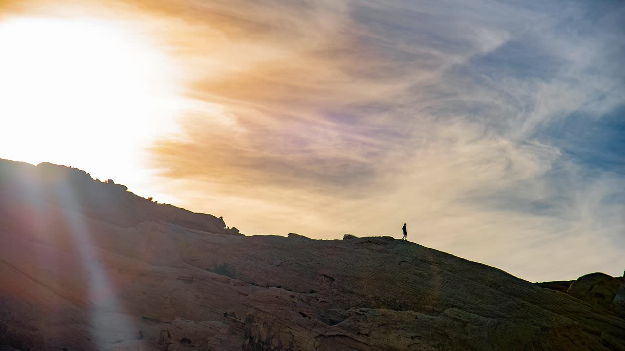 석양에 산등성이를 걷고 있는 등산객의 아름다운 시네마그래프