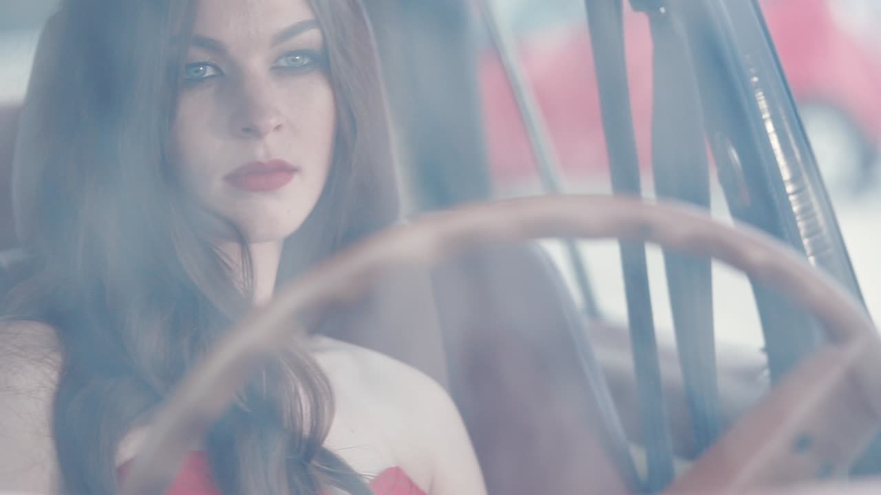 una mujer conduciendo un coche de época.