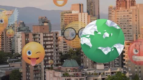 globo giratorio y múltiples iconos de emoji de cara flotando contra edificios altos en el fondo