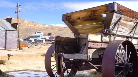 a panshot in a ghost town, rusted wagon