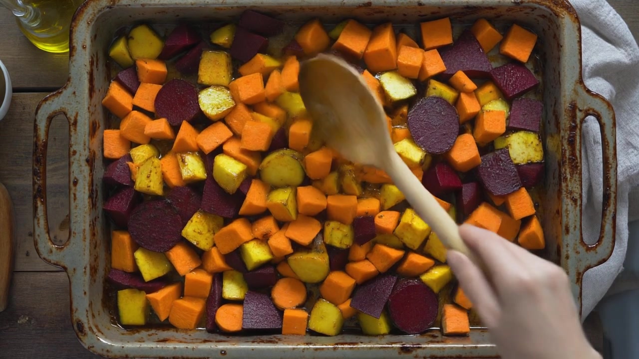 Person Mixing Roasted Vegetables in a Baking Tray