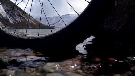 close up the calm water, rocks and a bicycle wheel in the main lagoon xinantecatl volcano in mexico, this is a tourist location in the beautiful nevado de toluca mountain