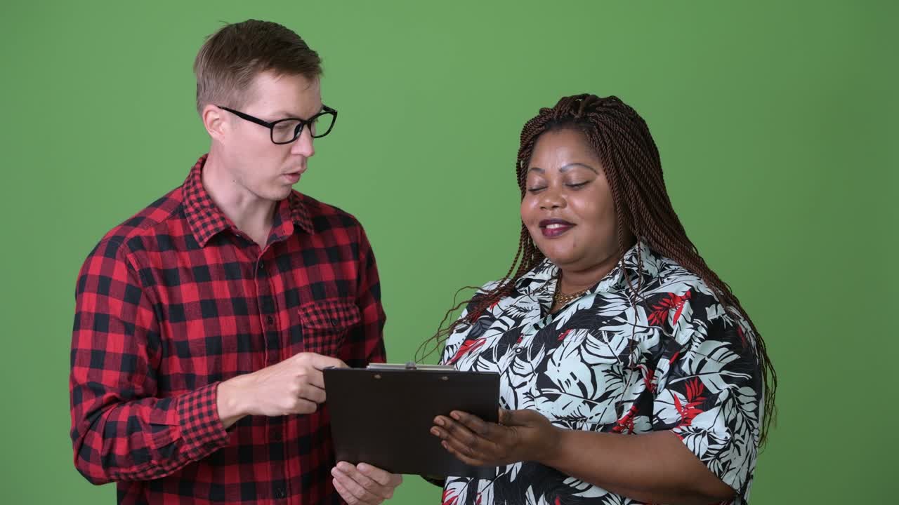 mujer africana con sobrepeso y un joven escandinavo juntos contra un fondo verde