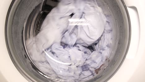taking out clean wet towel from washing drum close up view taking out clean wet towel from washing drum close up view
