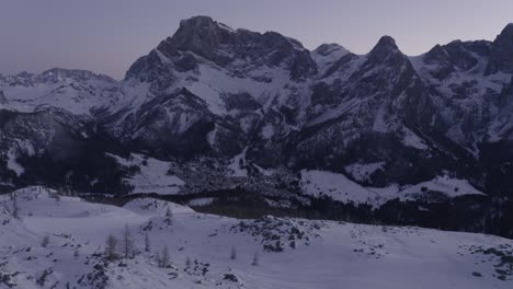 Toma-Aérea-Del-Paisaje-Invernal-Nevado-Con-Montañas-Durante-La-Hora-Azul-De-La-Mañana---Dolomitas,-Italia