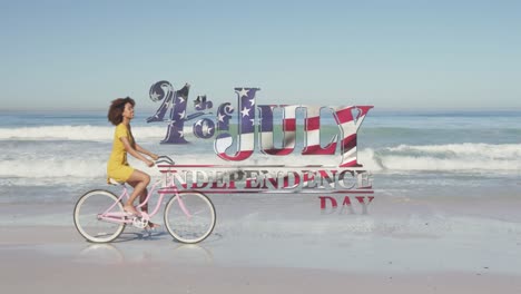 american flag waving over independence day text against woman riding bicycle on the beach