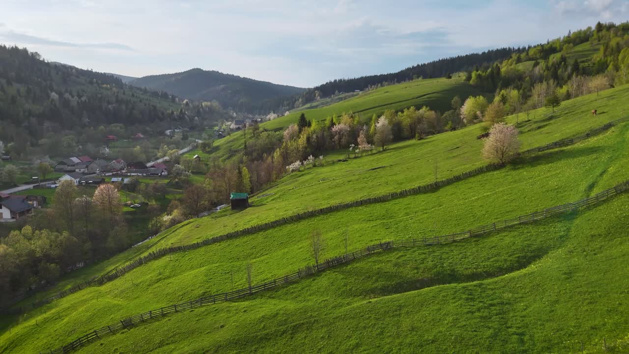 Romanian rural landscape with fenced hills and village