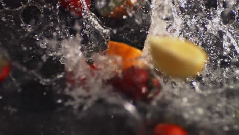 frutas cae en un recipiente de agua