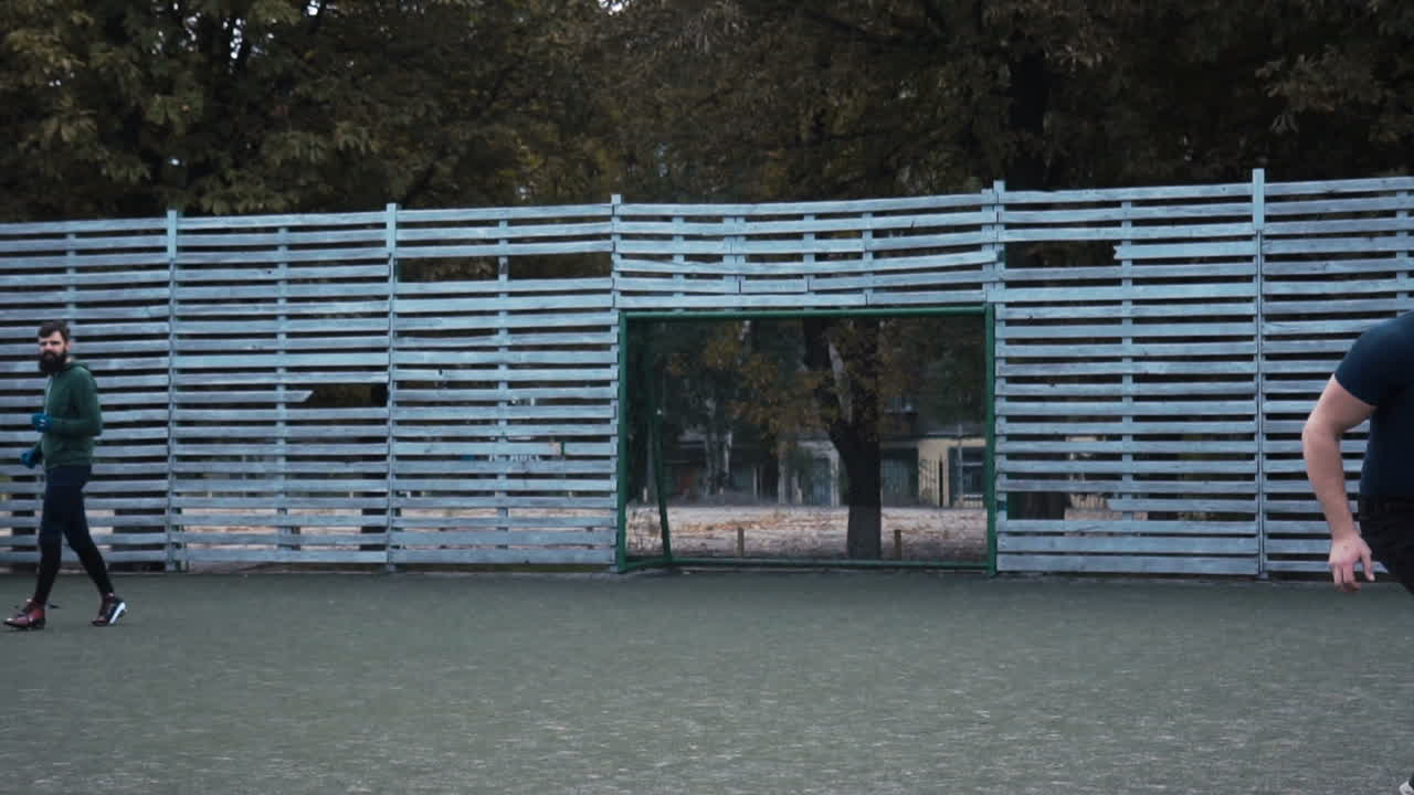 Two Men Playing American Football Outdoors