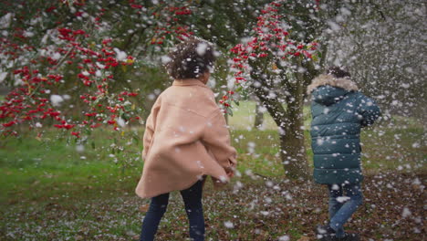 two children having fun playing in snow on winter walk in countryside - shot in slow motion