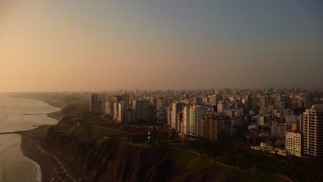 vista aérea con vistas a la costa verde y al paisaje urbano de miraflores, puesta de sol en lima, perú - pan, tiro con drones