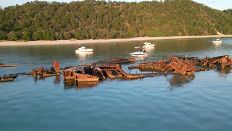 Panoramic-Landscape-White-Sand-beach-Island-with-Sank-Ship,-rusted-vehicle-in-blue-sea-Aerial-Drone,-daylight-view-at-Moreton-Island