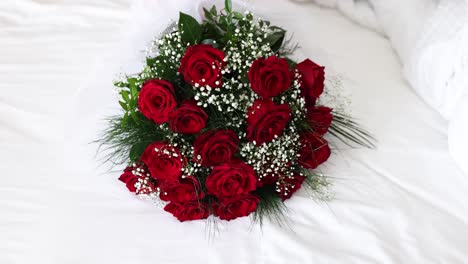bouquet of red roses on white sheets