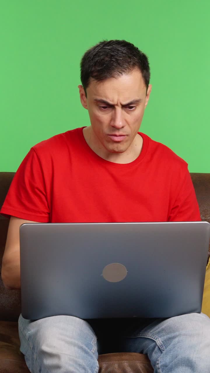 Man expressing various emotions while using laptop on green screen