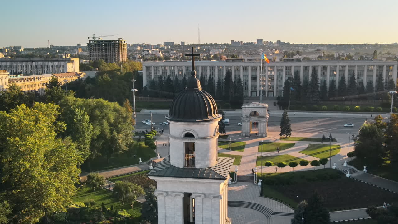 Aerial drone view of Chisinau downtown at sunset. Panorama view of Goverment building, Triumph Arch, bell tower, moving cars. Moldova