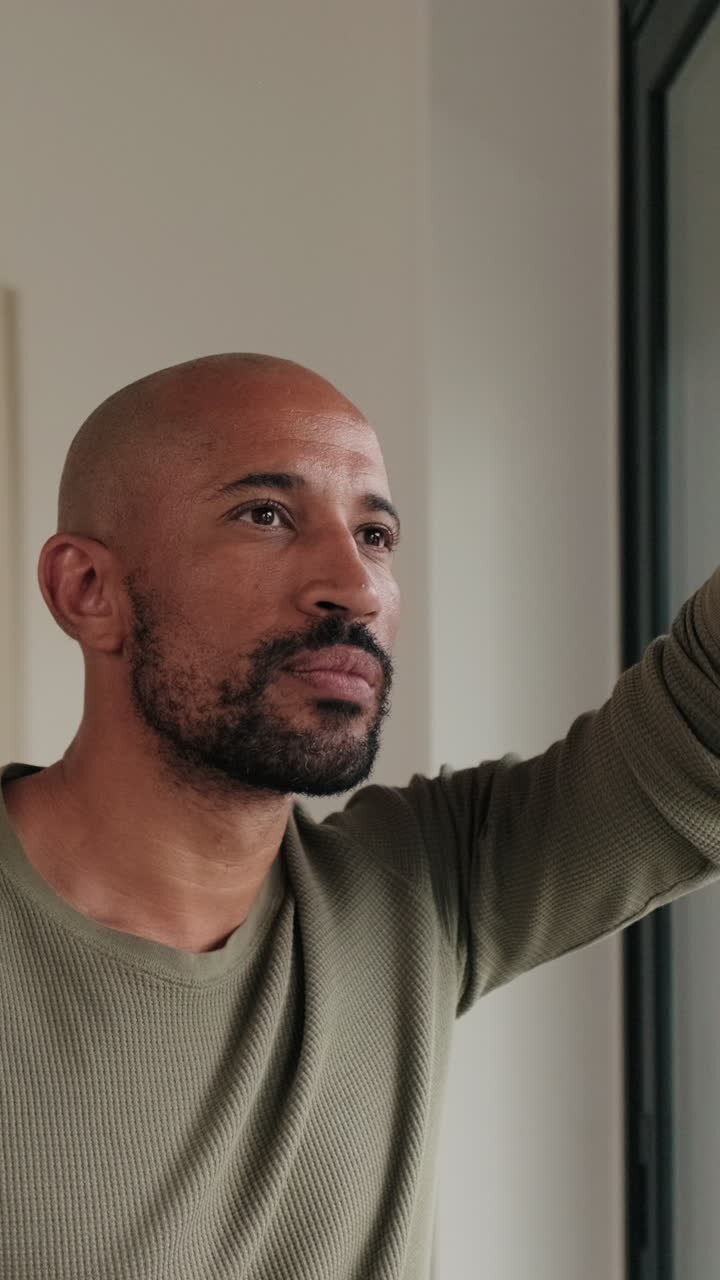 Couple Looks Out Window at Home