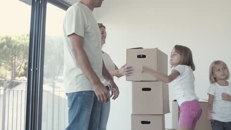 padres e hijas mudándose a un nuevo apartamento