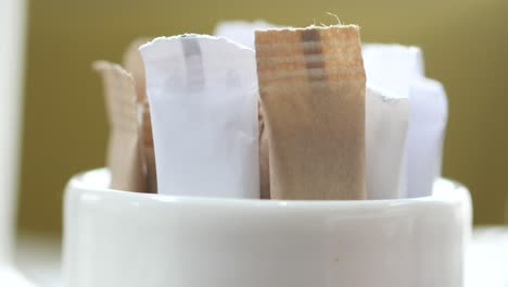 paquetes de azúcar en un recipiente blanco