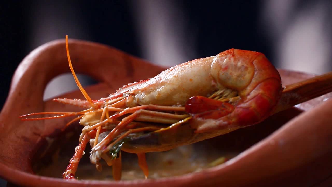 전통적인 점토 비에서 제공되는 뜨거운 새우 수프, 태국 요리의 본질을 포착합니다.