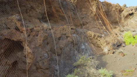 metal mesh on cliff prevents falling rocks, ensuring safety