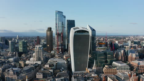 Slide-and-pan-footage-of-group-of-modern-tall-skyscrapers-in-City-business-district.-Walkie-Talkie-with-Sky-garden-at-top-in-foreground.-London,-UK